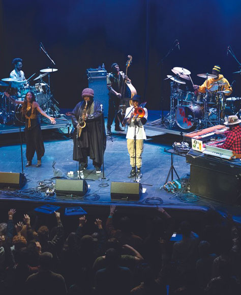 Band playing on stage with audience cheering.