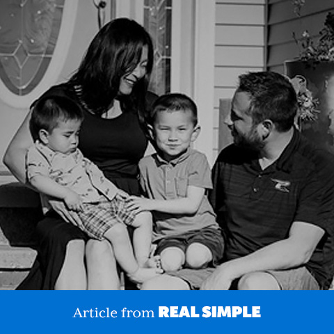 Family sitting outside their home.
