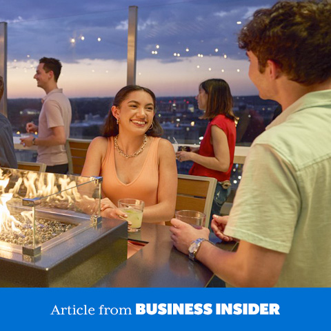 Young adults on a rooftop patio at dusk.