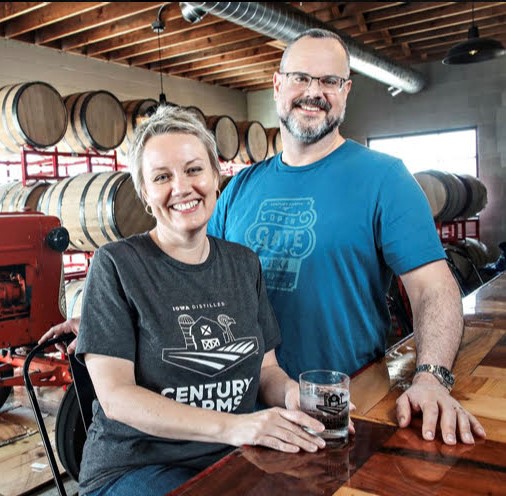 Amanda and Ryan standing in front of the bar at the Cedar Farms Distillery.