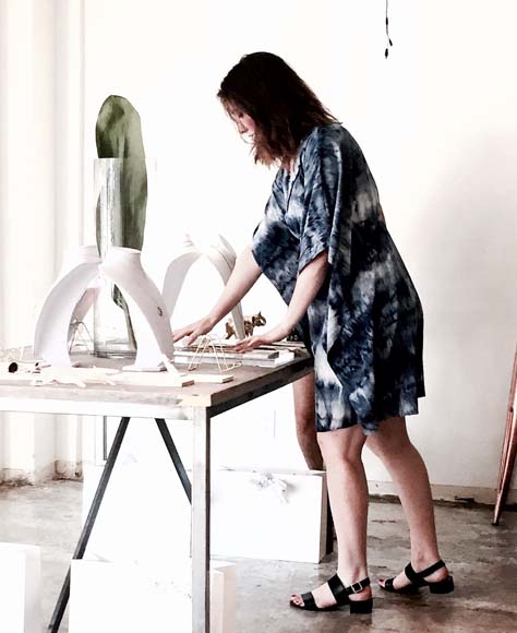 Delaney Evers standing at her work table.