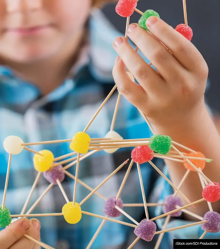 Young student doing a STEM project with gumdrops and toothpicks.