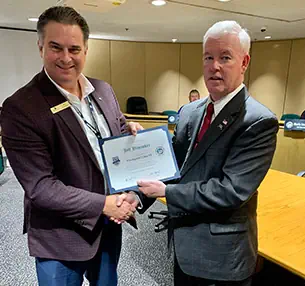 Jeff Bloemker receiving an award and shaking hands with the presenter.