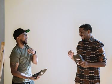 Pernell Cezar Jr. and Rod Johnson standing together and laughing.