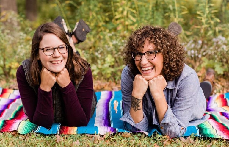 Kerri Sorrell & Jenn Riggs laying on a blanket outdoors