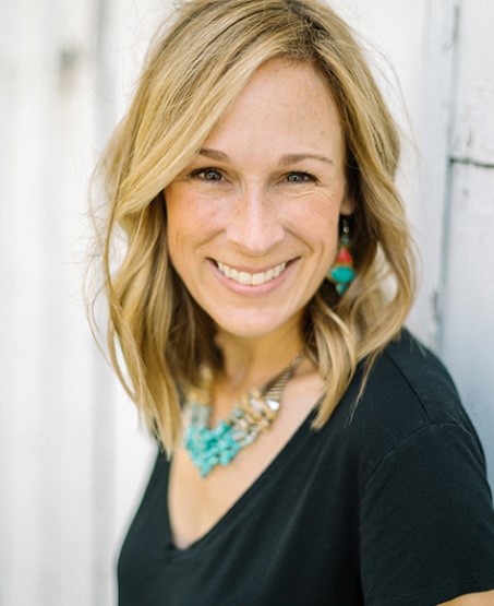 Marji Guyler-Alaniz smiling directly into the camera standing outside