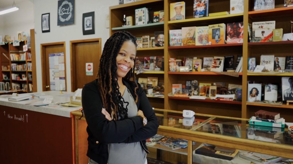 Amber Collins posing for a photo in her shop Soul Book Nook.